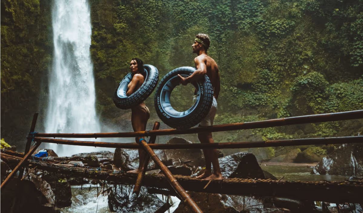 Two people carrying black inflatable pool float